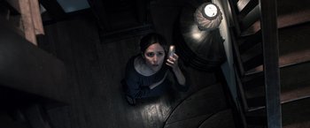 Movie still from “Insidious” (2010), directed by James Wan – A woman holding a cell phone while sitting on the floor; Close Up shot, Overhead angle