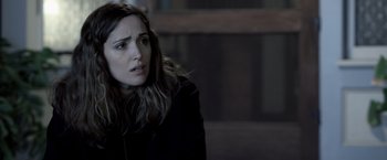 Movie still from “Insidious” (2010), directed by James Wan – A woman sitting in a dark room looking sad; Close Up shot, Over the shoulder angle