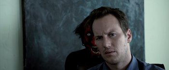Movie still from “Insidious” (2010), directed by James Wan – A man and a woman with a face mask on; Close Up shot, Over the shoulder angle