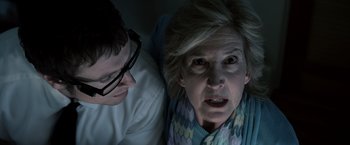 Movie still from “Insidious” (2010), directed by James Wan – An older woman and a younger man looking at each other; Close Up shot, Low angle