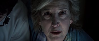 Movie still from “Insidious” (2010), directed by James Wan – An older woman with a strange look on her face; Close Up shot, Low angle