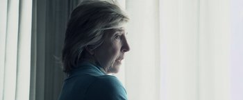 Movie still from “Insidious” (2010), directed by James Wan – An older woman looking out of a window; Close Up shot, Over the shoulder angle
