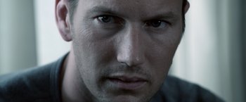 Movie still from “Insidious” (2010), directed by James Wan – A man's face with blue eyes; Extreme Close Up shot, Low angle