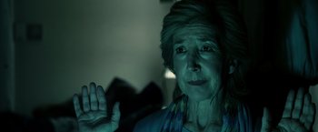 Movie still from “Insidious” (2010), directed by James Wan – An older woman is waving at the camera; Close Up shot, Low angle