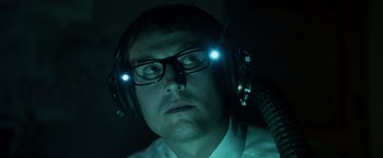 Movie still from “Insidious” (2010), directed by James Wan – A man wearing headphones and a white shirt; Close Up shot, Low angle