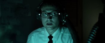 Movie still from “Insidious” (2010), directed by James Wan – A man wearing headphones and a white dress shirt; Close Up shot, Low angle