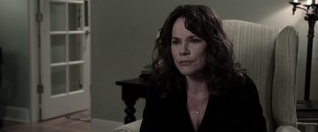 Movie still from “Insidious” (2010), directed by James Wan – A person sitting on a couch; Close Up shot, Over the shoulder angle