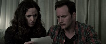 Movie still from “Insidious” (2010), directed by James Wan – A man and a woman looking at a piece of paper; Close Up shot, High angle