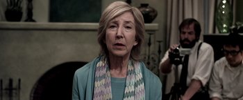 Movie still from “Insidious” (2010), directed by James Wan – An older woman wearing a blue sweater and a scarf; Close Up shot, Over the shoulder angle