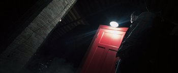 Movie still from “Insidious” (2010), directed by James Wan – A red door with a light shining on it; Medium shot, Low angle