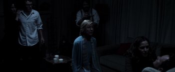 Movie still from “Insidious” (2010), directed by James Wan – A man taking a picture of a woman in a dark room; Medium shot, Over the shoulder angle