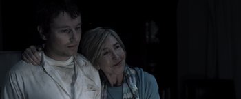 Movie still from “Insidious” (2010), directed by James Wan – An older woman sitting next to a younger man; Close Up shot, Low angle