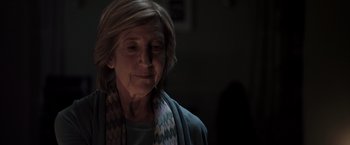 Movie still from “Insidious” (2010), directed by James Wan – An older woman wearing a scarf looking at the camera; Close Up shot, Over the shoulder angle