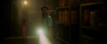 Movie still from “Insidious: The Last Key” (2018), directed by Adam Robitel – A woman standing in a room holding a flashlight; Medium shot, Low angle