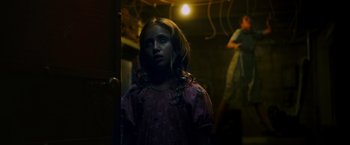 Movie still from “Insidious: The Last Key” (2018), directed by Adam Robitel – A young girl standing next to a door; Medium shot, Low angle
