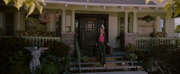 Movie still from “Insidious: The Last Key” (2018), directed by Adam Robitel – A woman carrying a bag and a suitcase down the steps of a house; Wide shot, Low angle