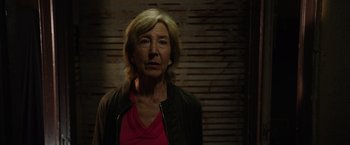 Movie still from “Insidious: The Last Key” (2018), directed by Adam Robitel – An older woman is standing in front of a brick wall; Close Up shot, Low angle