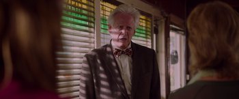 Movie still from “Insidious: The Last Key” (2018), directed by Adam Robitel – An older man wearing a suit and a bow tie; Close Up shot, Low angle