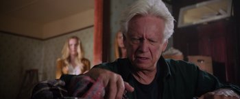 Movie still from “Insidious: The Last Key” (2018), directed by Adam Robitel – An older man with white hair is pointing to his face; Close Up shot, Over the shoulder angle