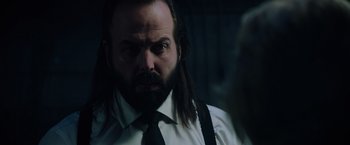 Movie still from “Insidious: The Last Key” (2018), directed by Adam Robitel – A man with long hair and a beard wearing a white shirt; Close Up shot, Over the shoulder angle
