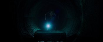 Movie still from “Insidious: The Last Key” (2018), directed by Adam Robitel – A person jumping in the air with a light in a dark tunnel; Wide shot, Low angle