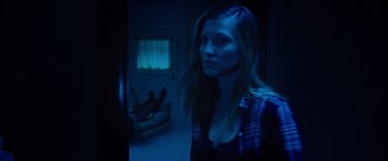Movie still from “Insidious: The Last Key” (2018), directed by Adam Robitel – A woman standing in a dark room looking at the camera; Medium shot, Low angle