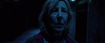 Movie still from “Insidious: The Last Key” (2018), directed by Adam Robitel – An older woman with a black collar is looking at the camera; Close Up shot, Low angle