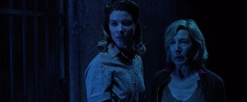 Movie still from “Insidious: The Last Key” (2018), directed by Adam Robitel – A woman in a blue shirt and a woman in a black shirt; Medium shot, Low angle