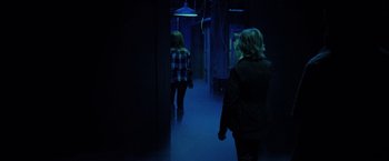 Movie still from “Insidious: The Last Key” (2018), directed by Adam Robitel – Two people walking down a hallway in a dark room; Wide shot, Over the shoulder angle