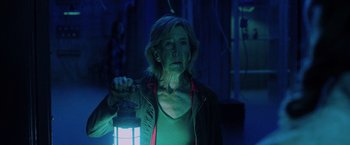 Movie still from “Insidious: The Last Key” (2018), directed by Adam Robitel – An older woman holding a lantern in a dark room; Medium shot, Low angle