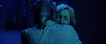 Movie still from “Insidious: The Last Key” (2018), directed by Adam Robitel – Two women hugging in a dark room with a blue light; Close Up shot, Over the shoulder angle