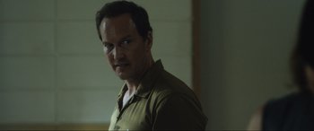 Movie still from “Insidious: The Red Door” (2023), directed by Patrick Wilson – A person wearing a green shirt; Close Up shot, Over the shoulder angle