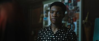 Movie still from “Insidious: The Red Door” (2023), directed by Patrick Wilson – A man in a black and white patterned shirt looking to his left; Close Up shot, Low angle