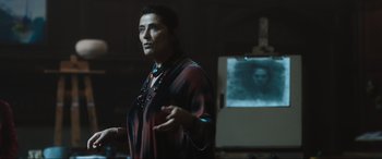 Movie still from “Insidious: The Red Door” (2023), directed by Patrick Wilson – A woman standing in front of a projector screen; Medium shot, Over the shoulder angle