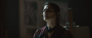 Movie still from “Insidious: The Red Door” (2023), directed by Patrick Wilson – A woman in a black and red shirt is looking up; Close Up shot, Low angle