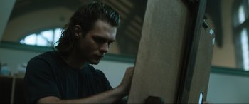 Movie still from “Insidious: The Red Door” (2023), directed by Patrick Wilson – A man holding a piece of wood in his hand; Close Up shot, Low angle