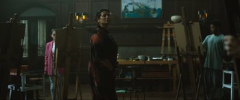 Movie still from “Insidious: The Red Door” (2023), directed by Patrick Wilson – A woman standing in front of an easel in an art studio; Medium shot, Low angle