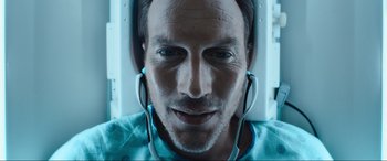 Movie still from “Insidious: The Red Door” (2023), directed by Patrick Wilson – A person wearing headphones; Close Up shot, Overhead angle