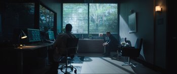 Movie still from “Insidious: The Red Door” (2023), directed by Patrick Wilson – Two people sitting in a room with a desk and a chair; Wide shot, Over the shoulder angle