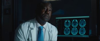 Movie still from “Insidious: The Red Door” (2023), directed by Patrick Wilson – A man wearing a lab coat sitting in front of a computer screen; Close Up shot, Low angle