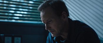 Movie still from “Insidious: The Red Door” (2023), directed by Patrick Wilson – A person sitting down; Close Up shot, Low angle