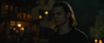 Movie still from “Insidious: The Red Door” (2023), directed by Patrick Wilson – A man with long hair is standing in the dark; Close Up shot, Over the shoulder angle