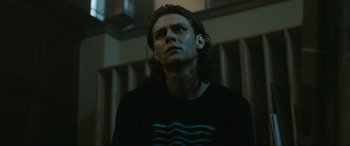 Movie still from “Insidious: The Red Door” (2023), directed by Patrick Wilson – A man with long hair is looking into the distance; Close Up shot, Low angle