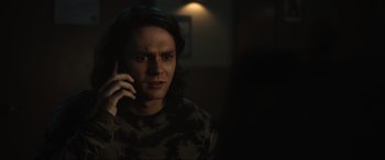 Movie still from “Insidious: The Red Door” (2023), directed by Patrick Wilson – A man is talking on a cell phone in a dark room; Close Up shot, Over the shoulder angle