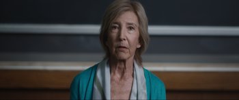 Movie still from “Insidious: The Red Door” (2023), directed by Patrick Wilson – An older woman wearing a blue jacket looking at the camera; Close Up shot, Low angle