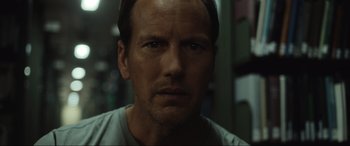 Movie still from “Insidious: The Red Door” (2023), directed by Patrick Wilson – A man's face in a dark room; Close Up shot, Low angle