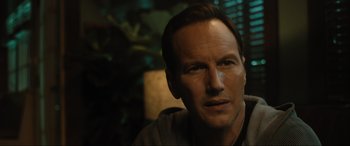 Movie still from “Insidious: The Red Door” (2023), directed by Patrick Wilson – A person wearing a gray shirt; Close Up shot, Over the shoulder angle