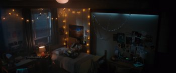 Movie still from “Insidious: The Red Door” (2023), directed by Patrick Wilson – A woman sitting on a bed in a room with lights; Wide shot, High angle