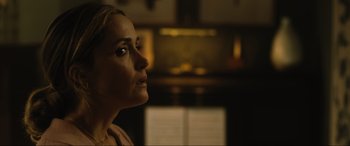 Movie still from “Insidious: The Red Door” (2023), directed by Patrick Wilson – A person with a book in the background; Close Up shot, Over the shoulder angle