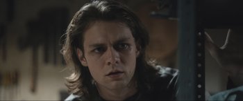 Movie still from “Insidious: The Red Door” (2023), directed by Patrick Wilson – A young man with long hair stares into the camera; Close Up shot, Low angle